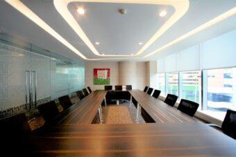 A conference room featuring a long table surrounded by several chairs, designed for meetings and discussions.